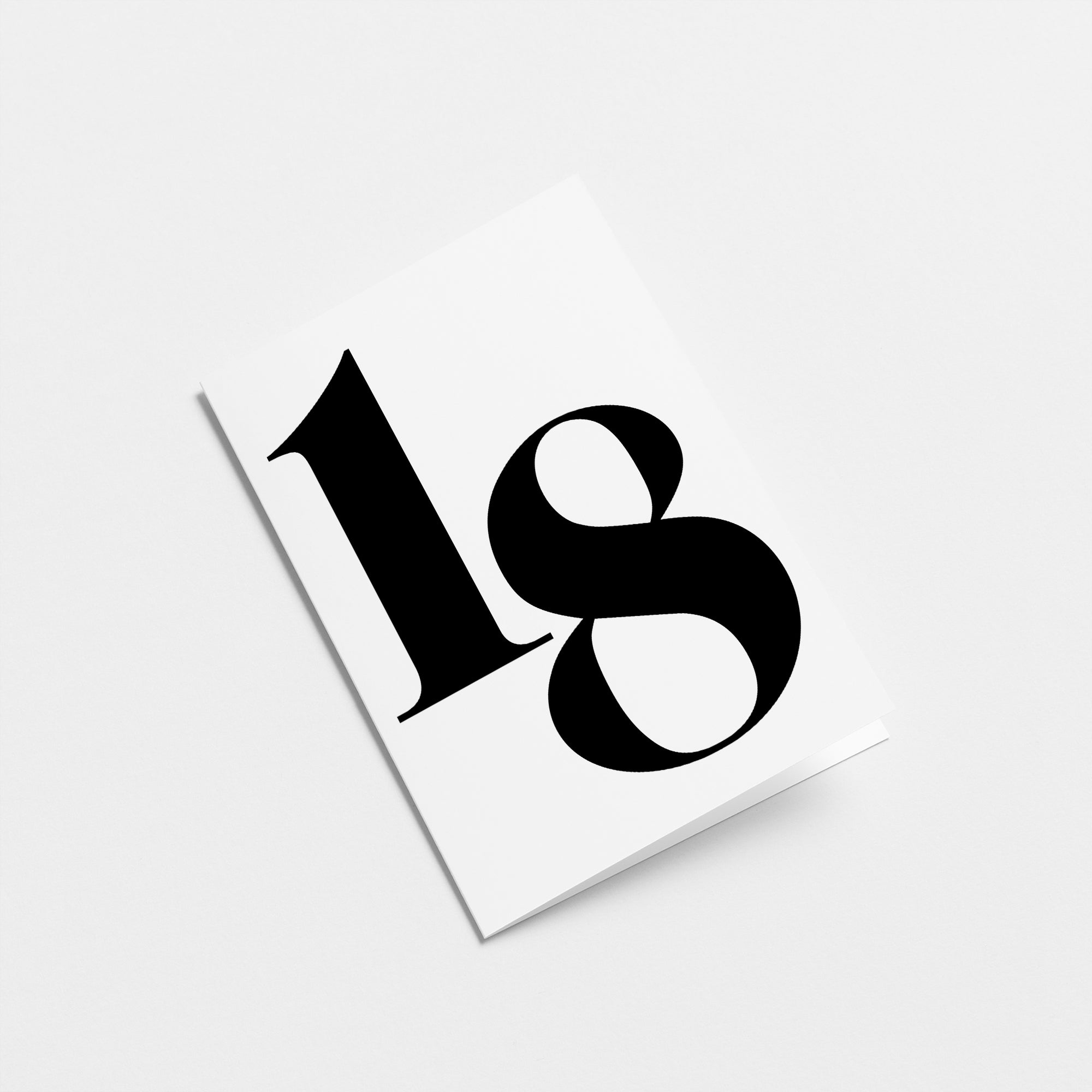 white 18th milestone age card with black number 18