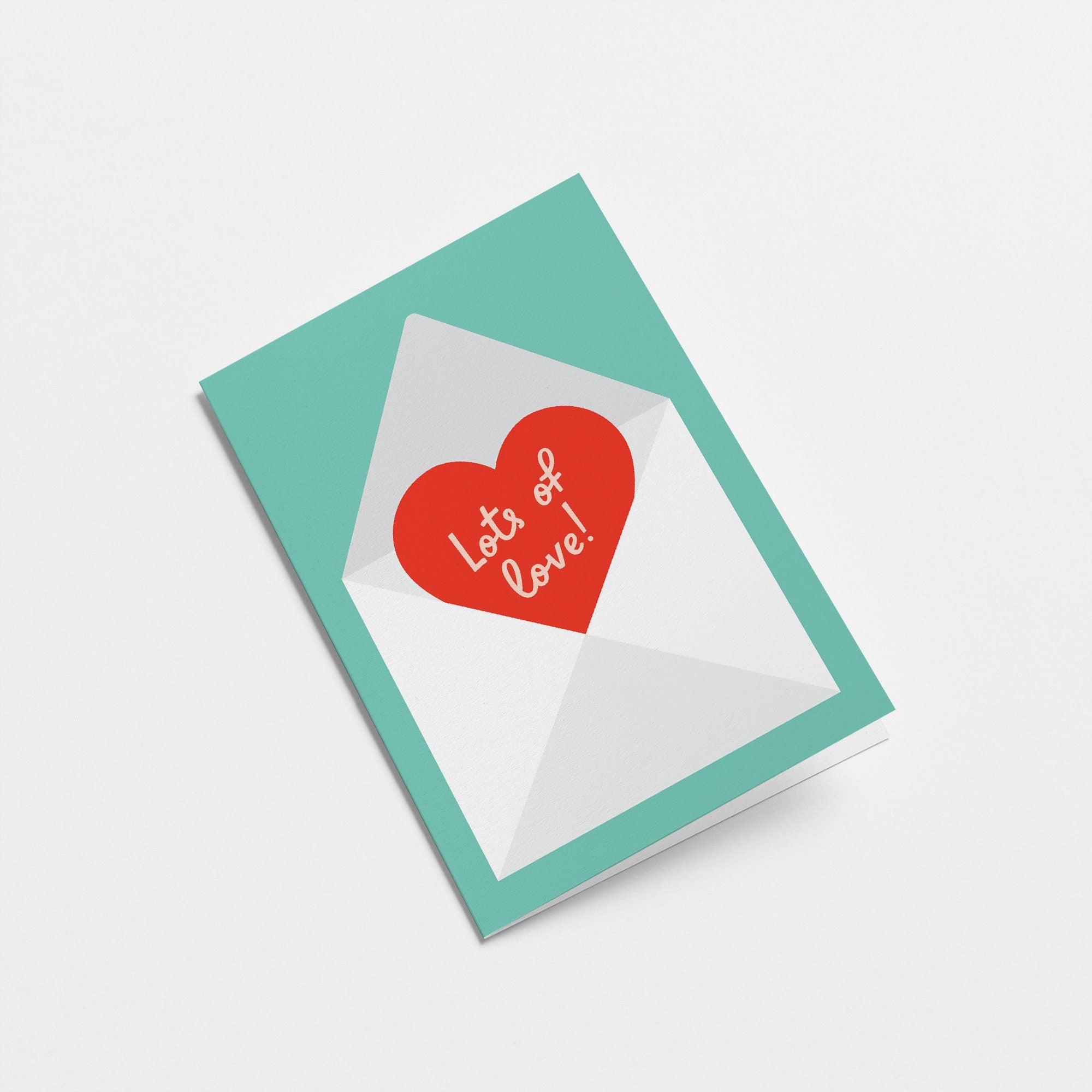 love card with a red heart shape in a white envelope with a text that says lots of love