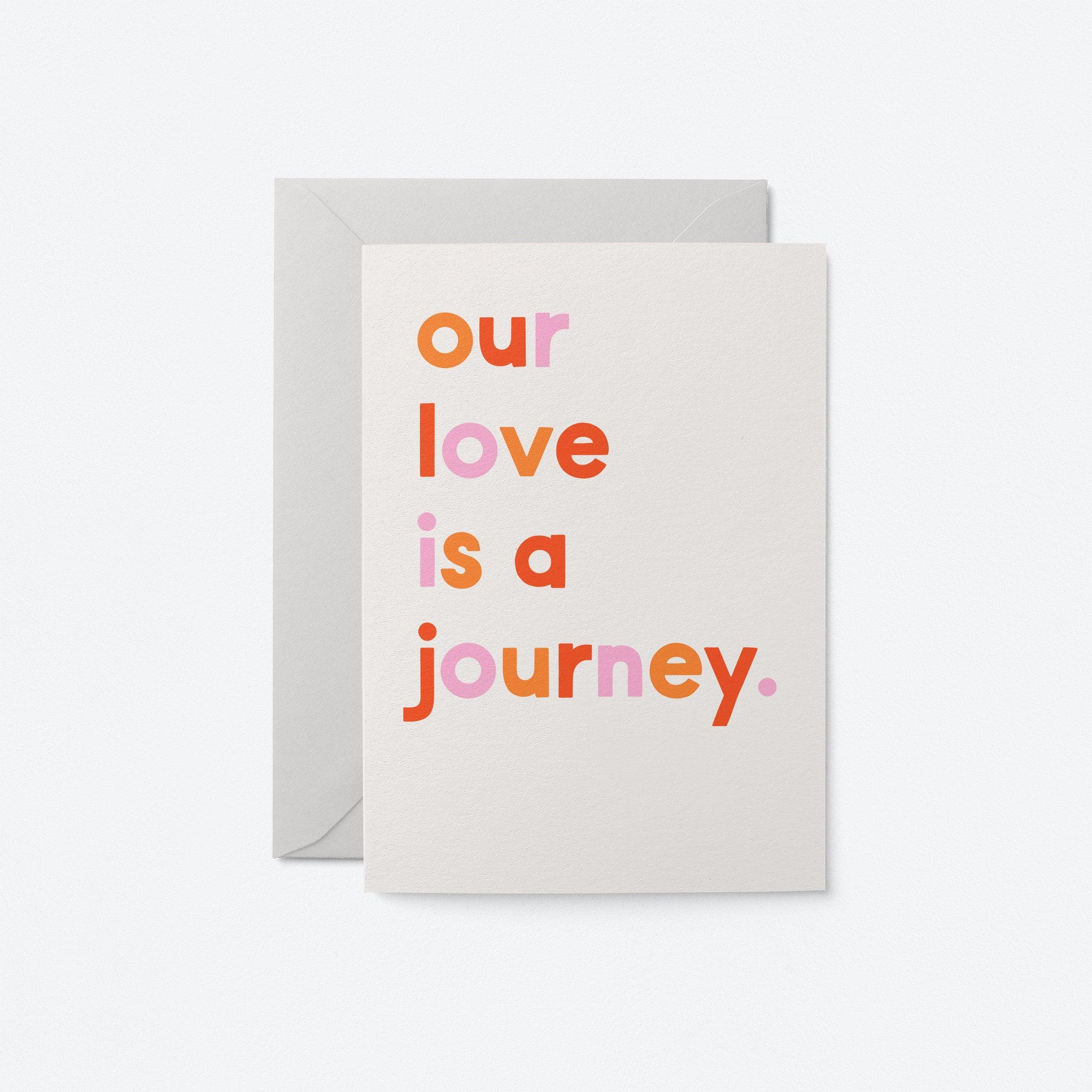 typographic greeting card and text says: our love is a journey. Grey envelope on white background.